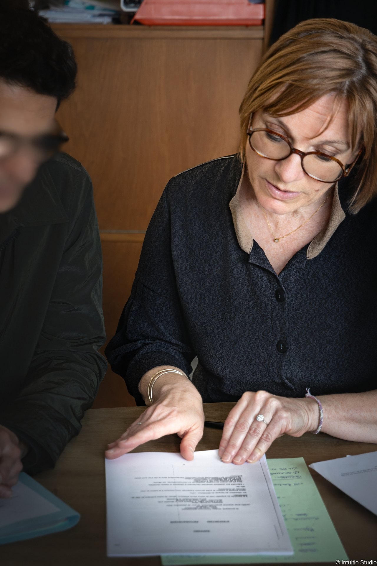 Fabienne Lacoste en rendez-vous avec un client, dossier ouvert sur la table