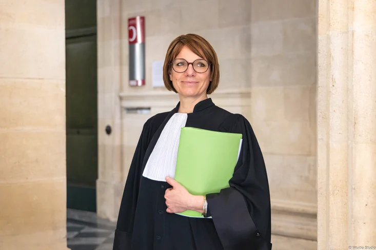 Fabienne Lacoste en robe d'avocate, un dossier à la main